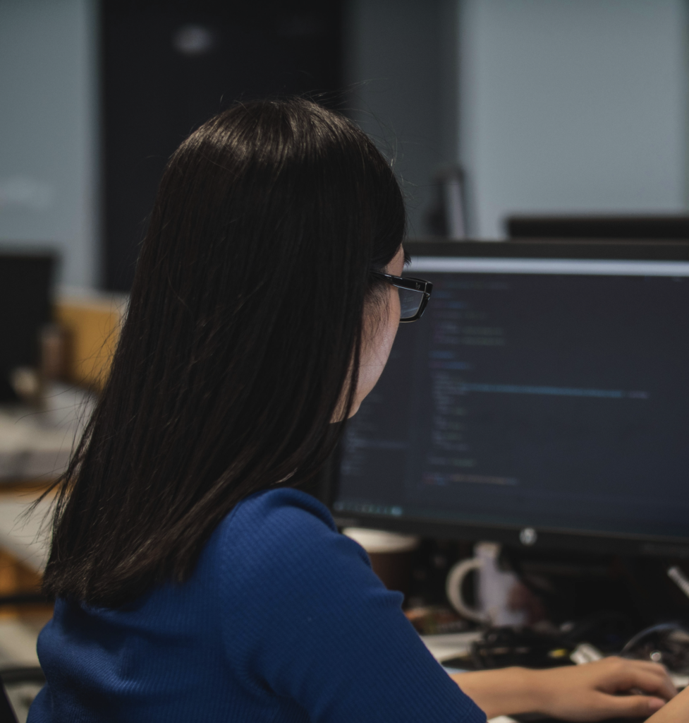Photo showing a person sitting at a computer using a code editor application